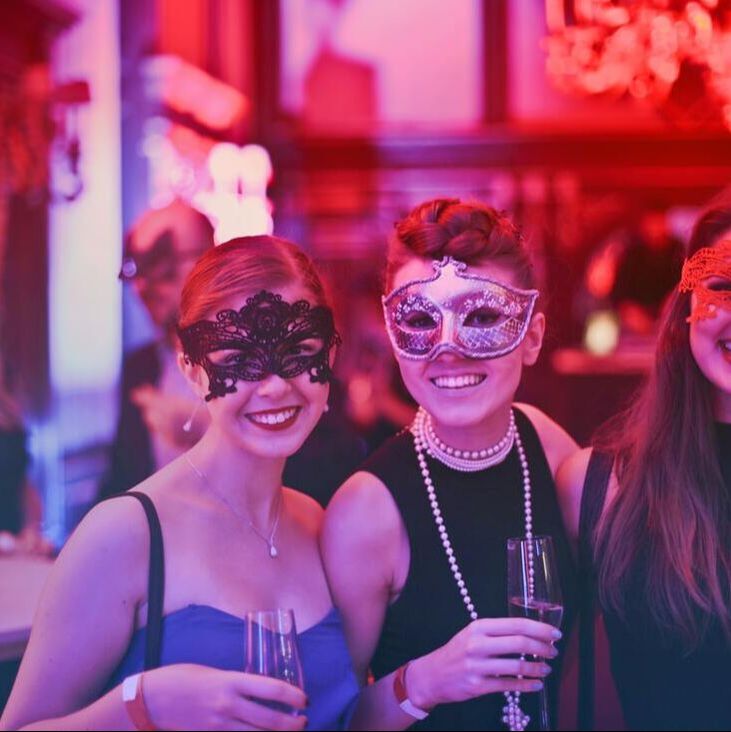 Two masked women celebrating a birthday party after riding in a party bus rental and limo rental.
